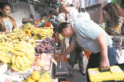 天涯區執法人員檢查水果攤上的秤具
